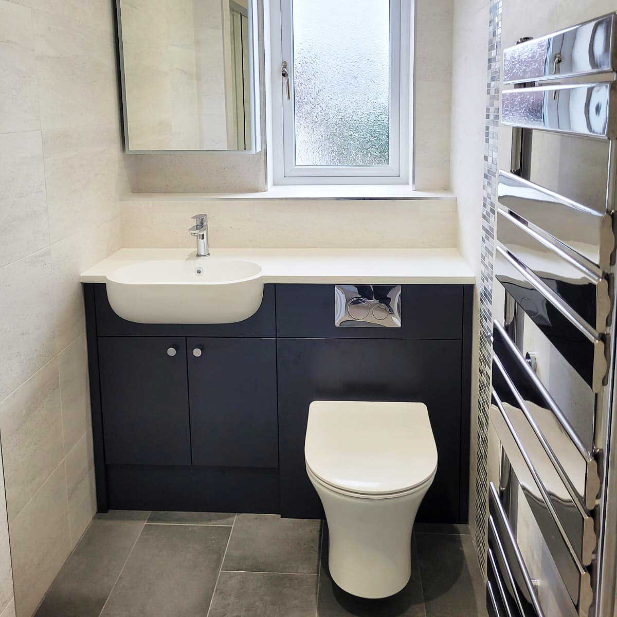 Roper Rhodes R2 dark blue fitted bathroom furniture and white composite worktop in an ensuite bathroom in Lytchett Matravers by Room H2o