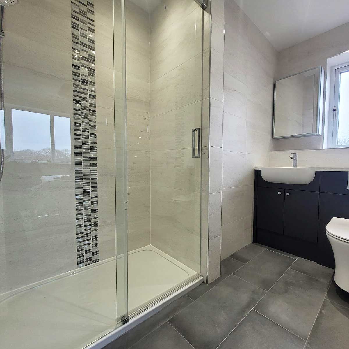 Enlarged shower in this modern ensuite in Lytchett Matravers was created by taking some space from a large built-in wardrobe in the main bedroom