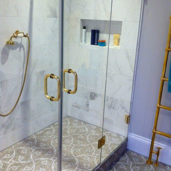 Bespoke frameless hinged shower door with 2 inline panels and gold fittings by Room h2o