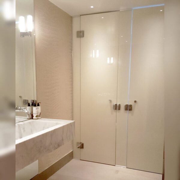Painted frameless glass doors for commercial washroom by Room H2o