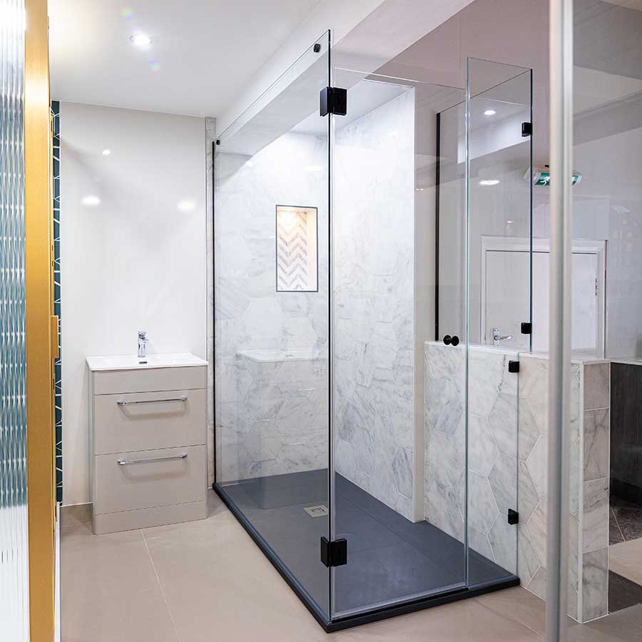 Frameless glass shower enclosure with black fittings and slate effect shower tray