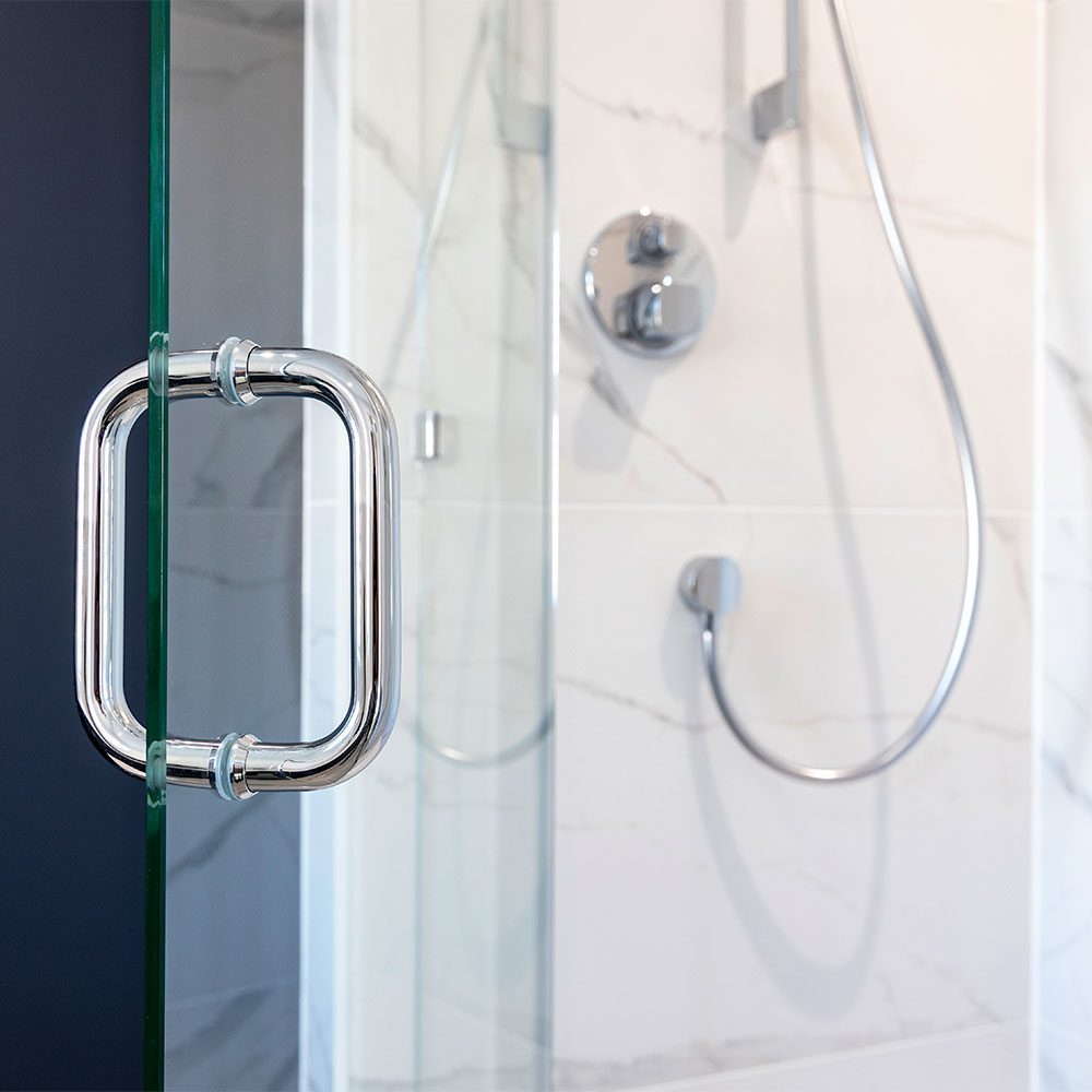 Elegant chrome D handle fitted to a bespoke frameless glass shower door by Room H2o